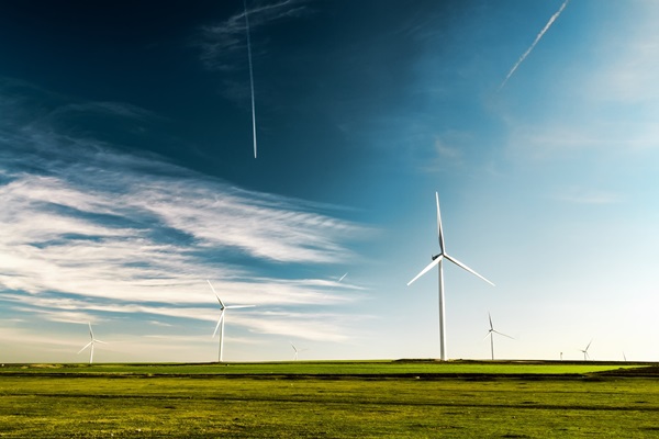 Wind turbines in field under blue sky