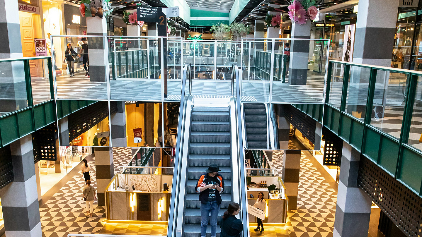 people on escalators in a mall
