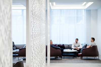 a room with a white screen and people sitting on the couch