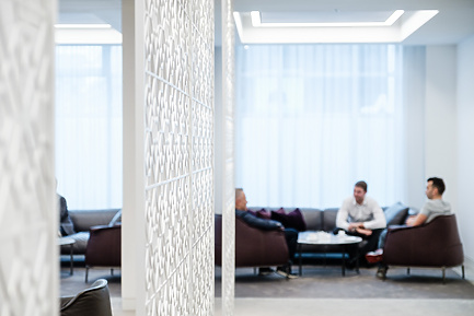 a room with a white screen and people sitting on the couch