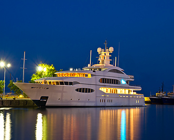 a large white boat in water at night
