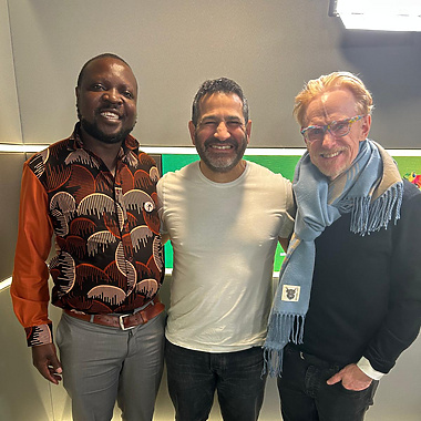 a group of men standing together smiling