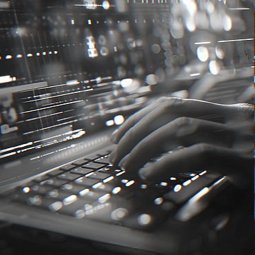 Person typing on a lit up laptop