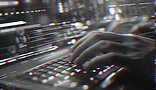 Person typing on a lit up laptop