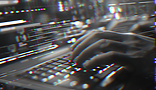 Person typing on a lit up laptop