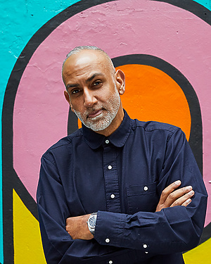 a person standing in front of a colorful wall