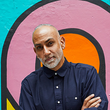 a person standing in front of a colorful wall