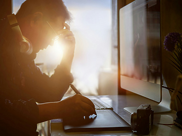 Shot of stressed man using digital graphic tablet while working at modern office