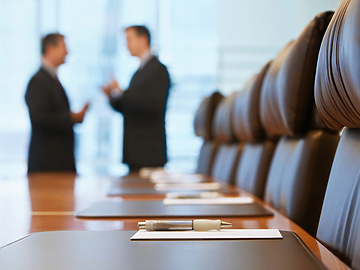 a pen on a table in a conference room with people talking in the background