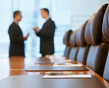 a pen on a table in a conference room with people talking in the background