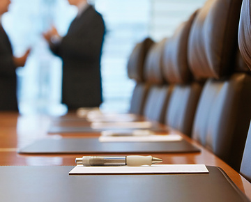 a pen on a table in a conference room with people talking in the background