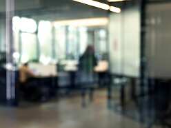 a blurry image of an office with a person in the background
