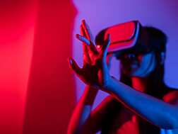 Young woman using glasses of virtual reality on dark background. Smartphone using with VR headset,virtual reality,future technology concept.