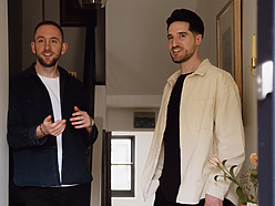 two men standing in a hallway