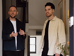 two men standing in a hallway
