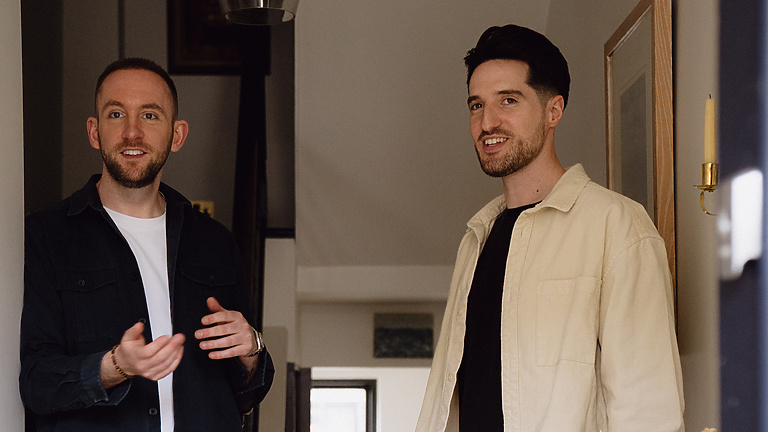 two men standing in a hallway