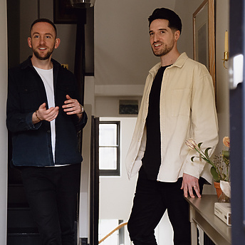 two men standing in a hallway