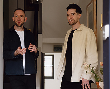 two men standing in a hallway