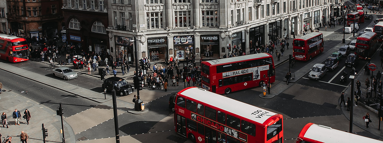 a group of people walking on a street with buses and people