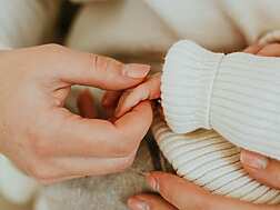 A person holding a baby's hand