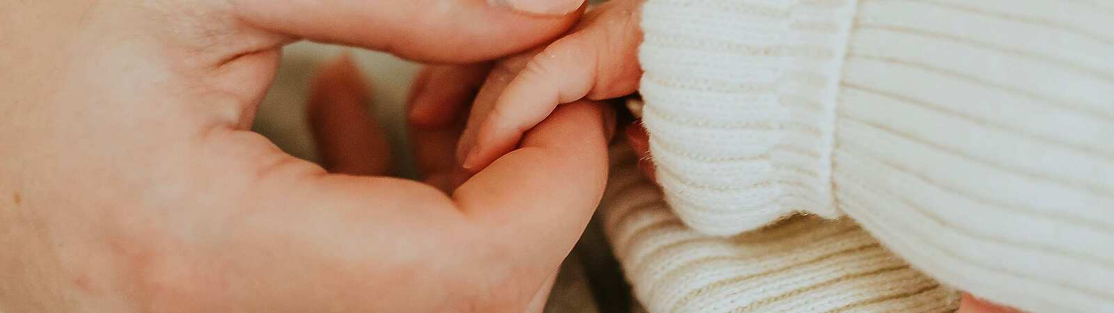 A person holding a baby's hand