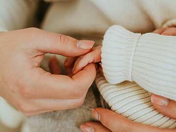 A person holding a baby's hand