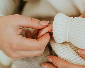A person holding a baby's hand