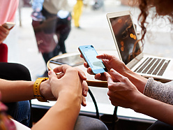 Two people in public space looking at mobile device