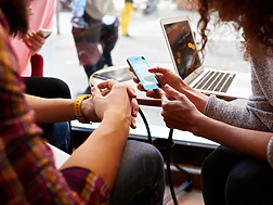 Two people in public space looking at mobile device