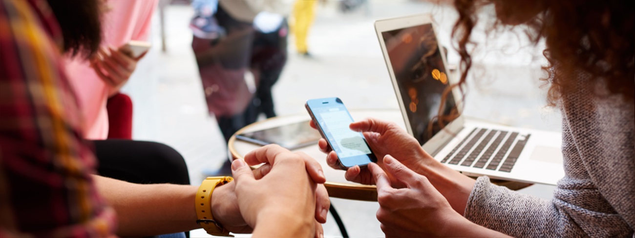 Two people in public space looking at mobile device