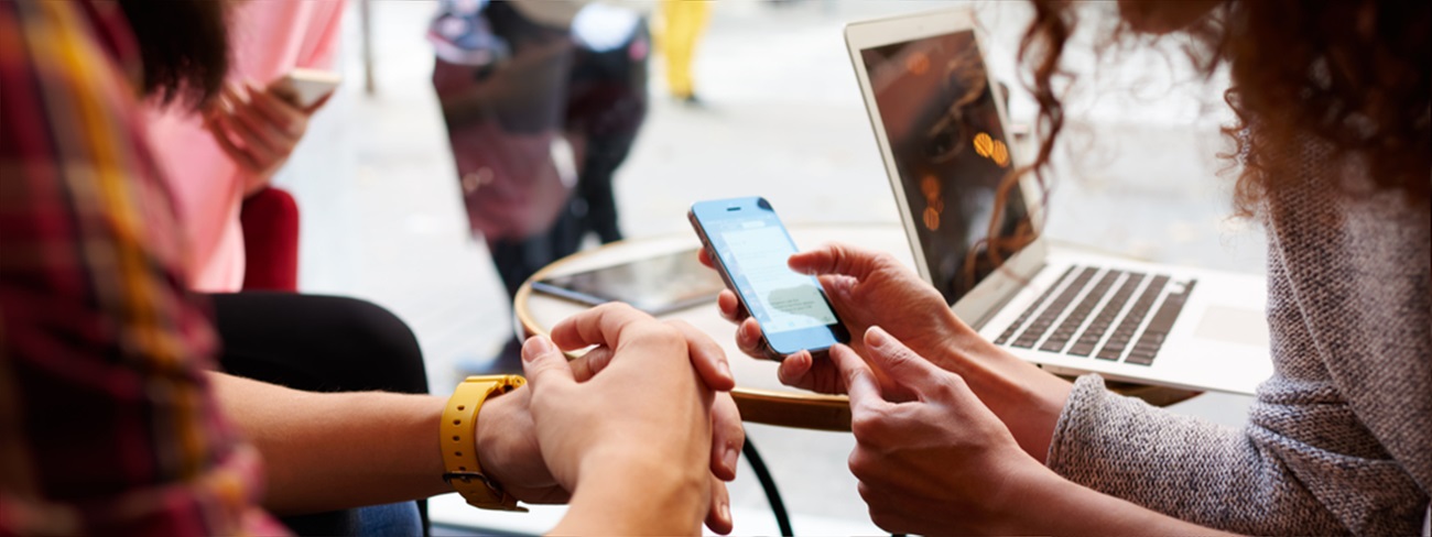 Two people in public space looking at mobile device