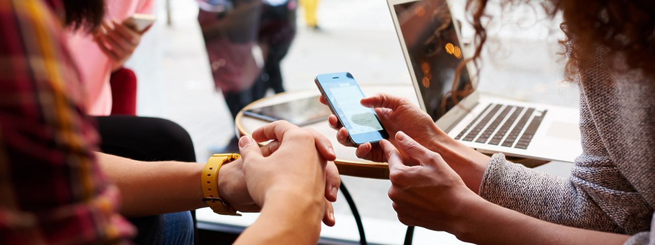 Two people in public space looking at mobile device