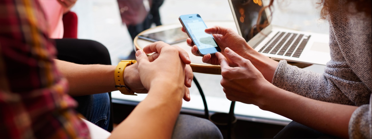 Two people in public space looking at mobile device