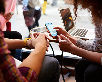 Two people in public space looking at mobile device