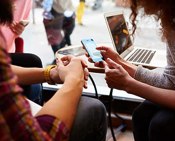 Two people in public space looking at mobile device