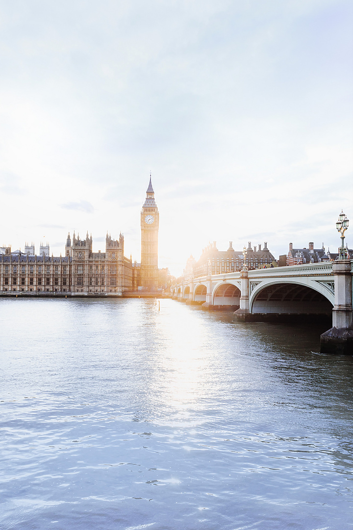 a bridge over water with a clock tower and a building