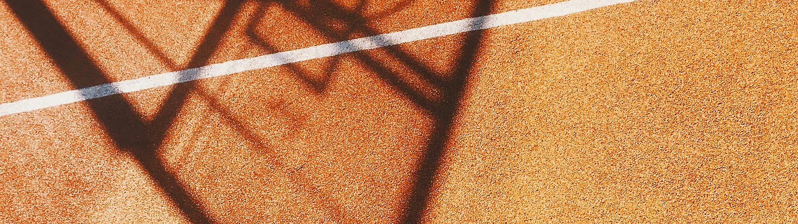 a shadow of a basketball hoop on a court