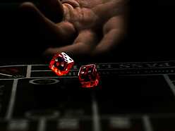 a hand throwing red dice