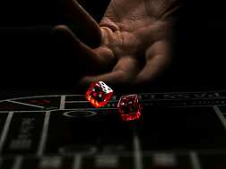 a hand throwing red dice