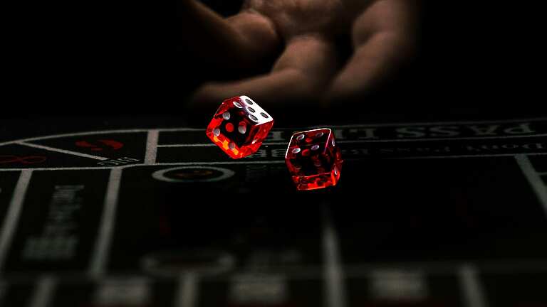 a hand throwing red dice