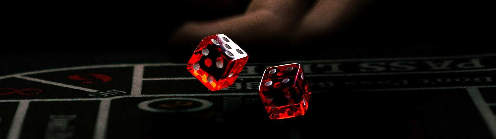 a hand throwing red dice