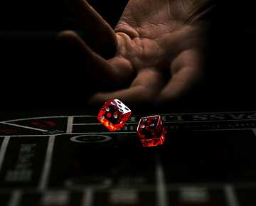 a hand throwing red dice
