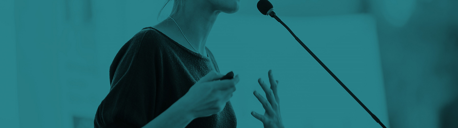 Woman speaking in front of Mic