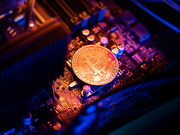 Bitcoin Cryptocurrency coin on a PC computer motherboard, crypto currency mining concept