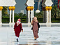 two women walking in a large plaza