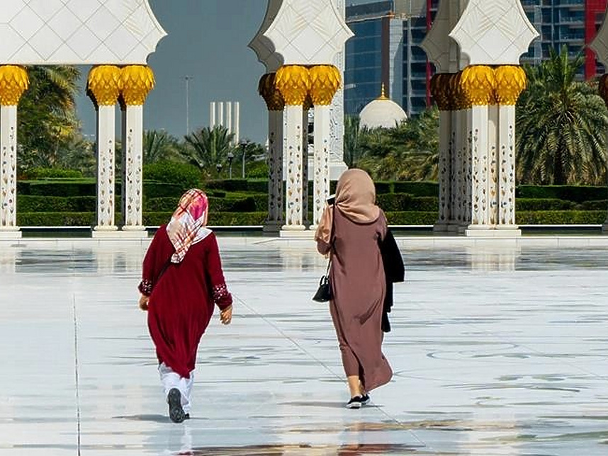 two women walking in a large plaza