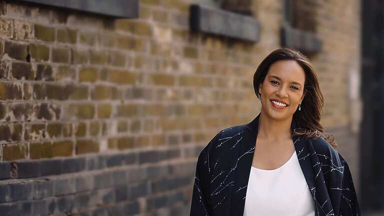 a person standing in front of a brick wall