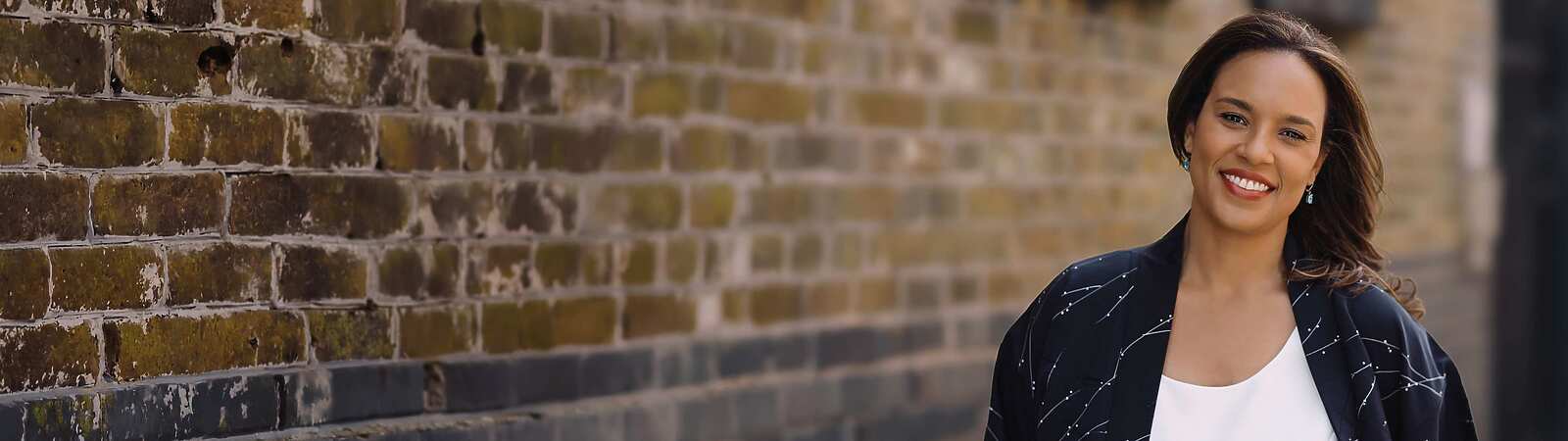 a person standing in front of a brick wall