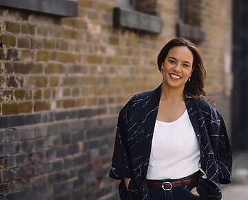 a person standing in front of a brick wall