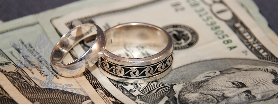 Wedding rings on top of dollar bills